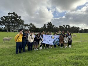 Students at the school farm holding a banner as part of teh Santa Laurensia Sister School International Cultural Exchange
