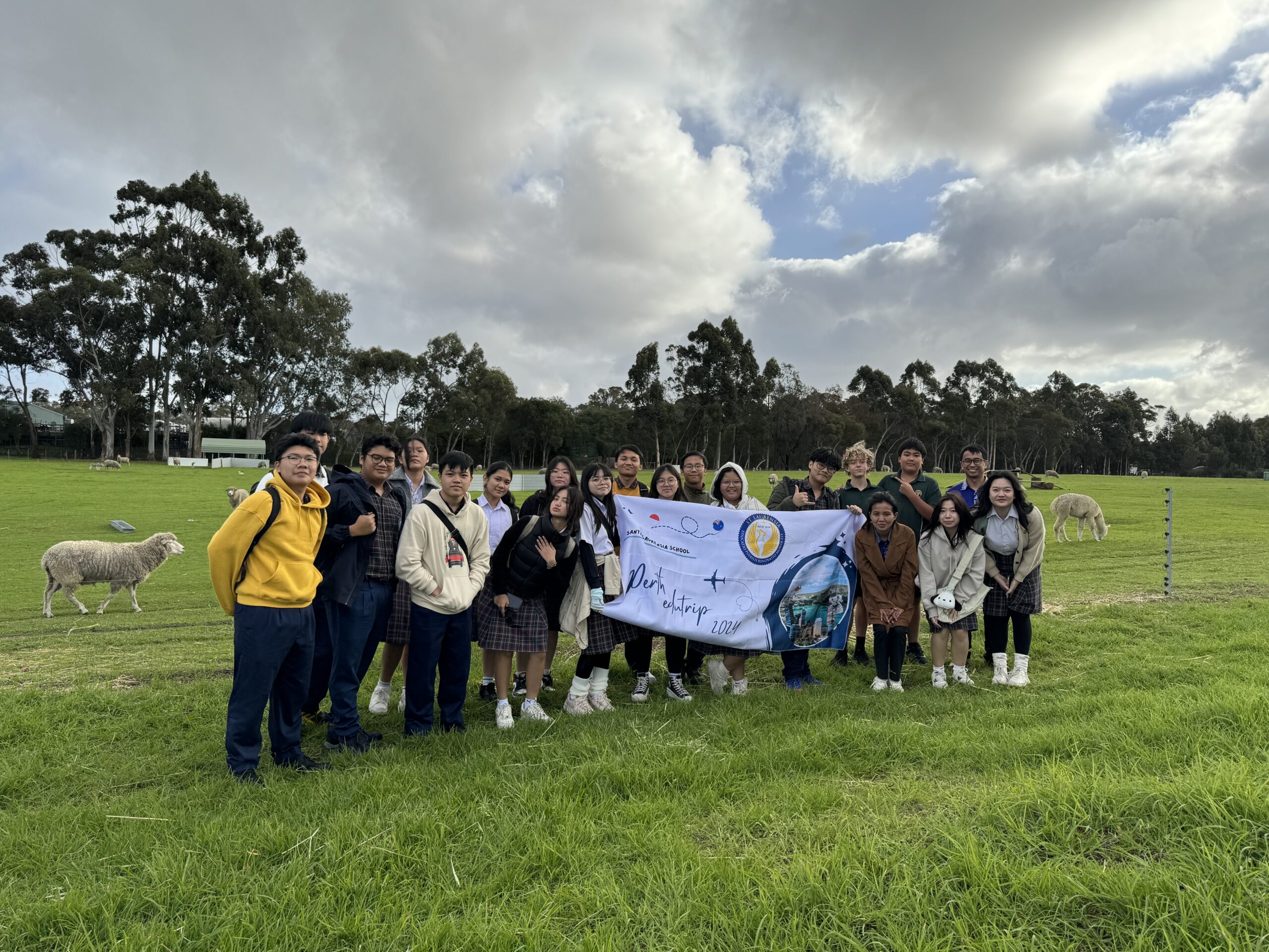 Students at the school farm holding a banner as part of teh Santa Laurensia Sister School International Cultural Exchange